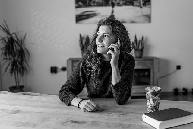 A sleep consultant, a young woman sitting at a table holding a mobile phone